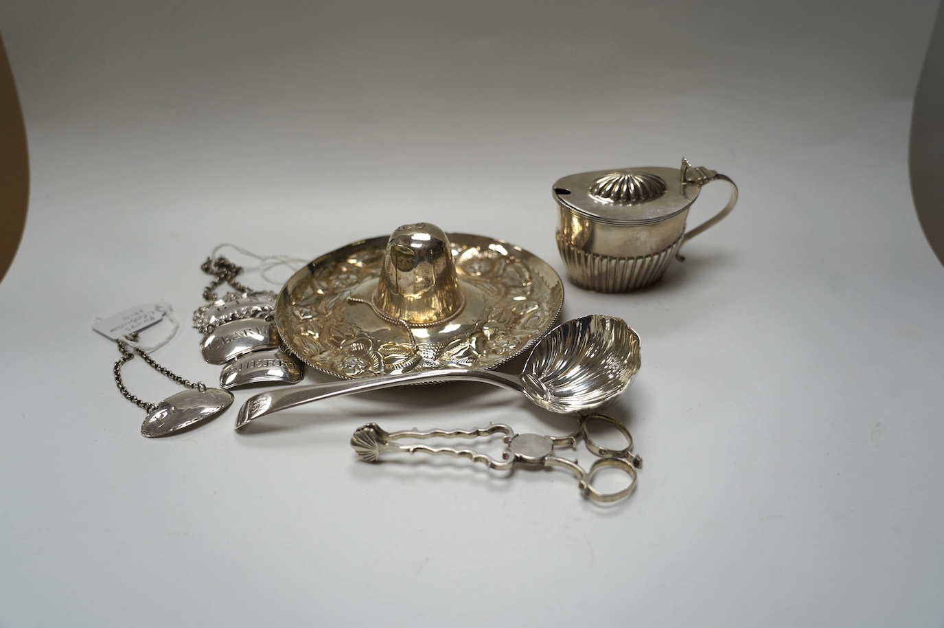 Four assorted 19th century silver wine labels, including a pair 'Sherry & Claret' by Joseph Wilmore, Birmingham, 1810, a Mexican 925 hat, a George III sauce ladle, by Eley & Fearn, London, 1802, a pair of silver sugar ni